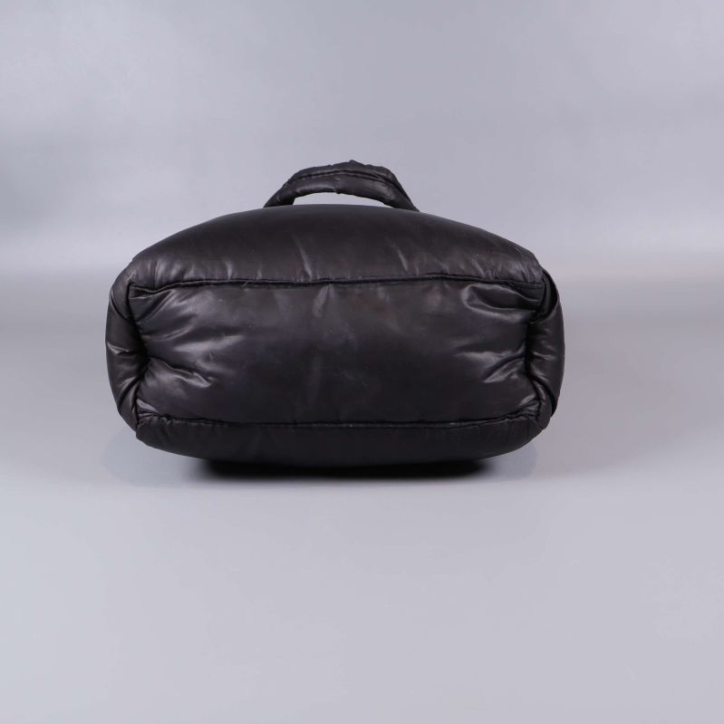 Undersidan av vadderad svart väska med slät finish