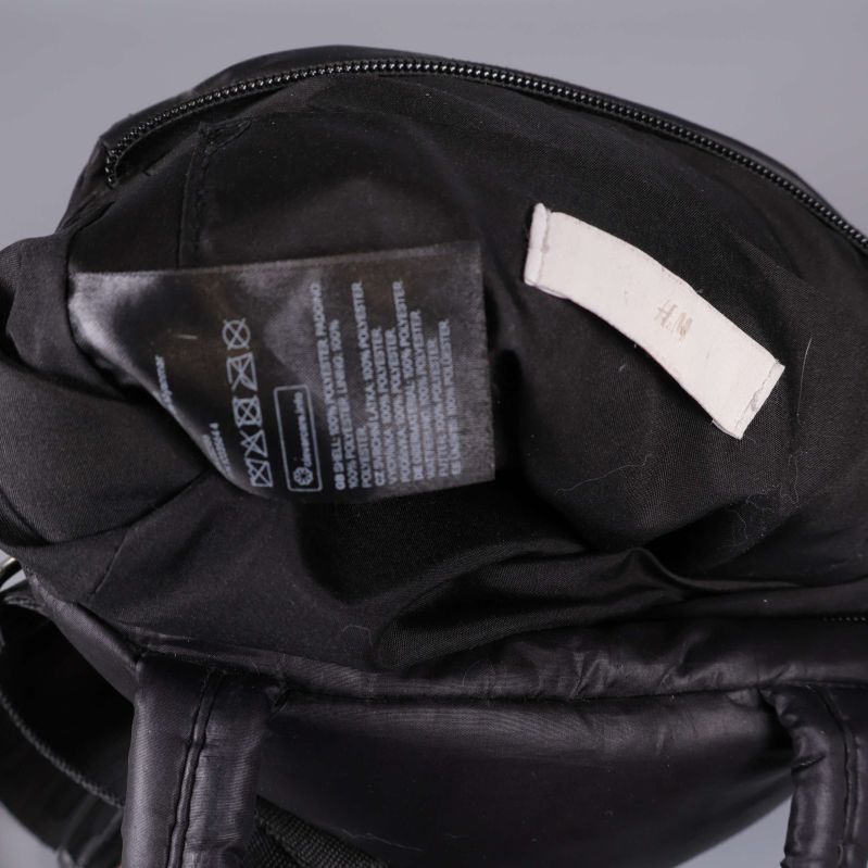 Närbild på inneretikett och skötselråd i väskans foder