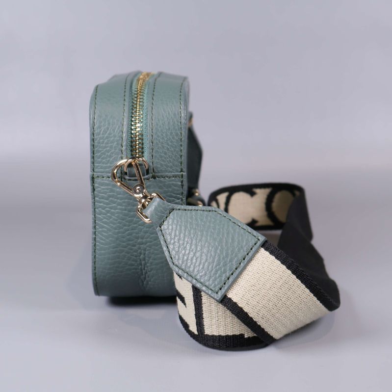 Sidovy av blågrön handväska med guldfärgade detaljer