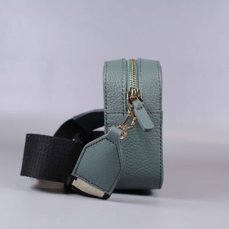 Blågrön handväska sedd från sidan med axelrem