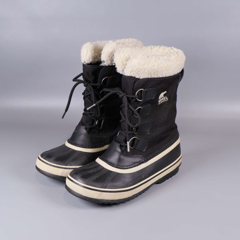 Svarta vinterkängor med vit sula och ullfoder sidovy