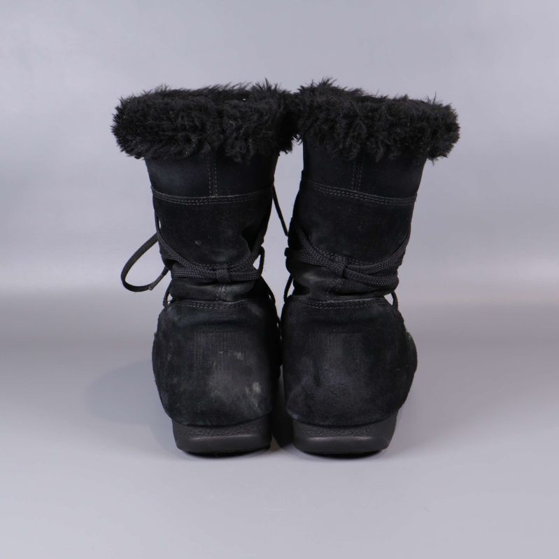 Bakre vy på svarta boots med synlig fluffig kant