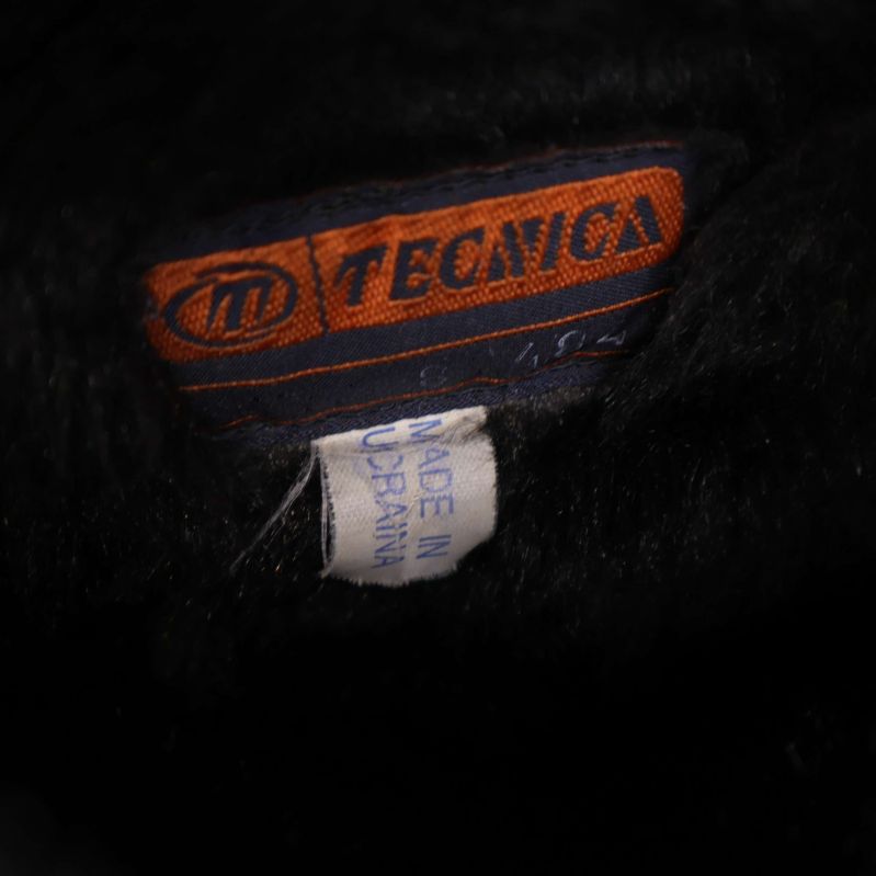 Närbild på svarta bootsens Tecnicamärke och tillverkningsetikett