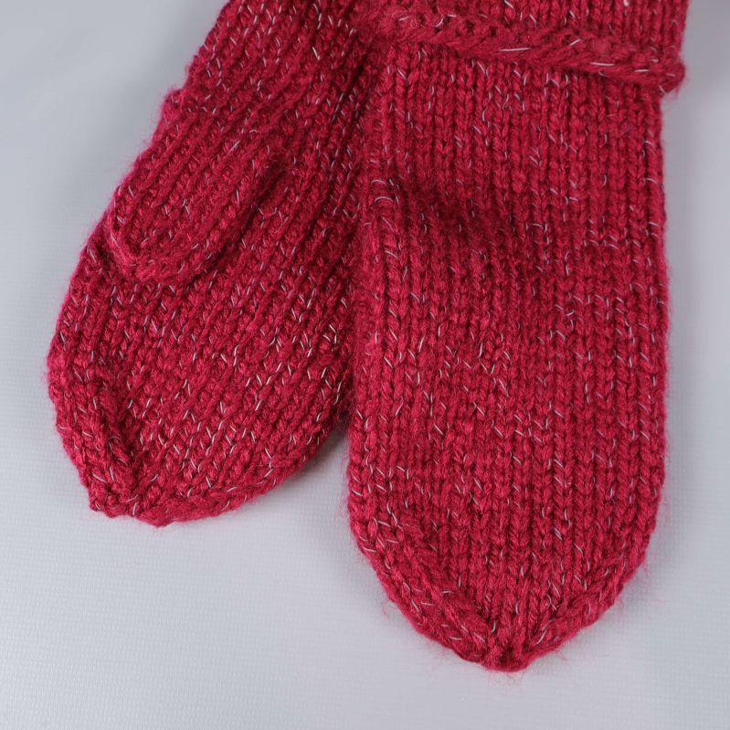 Närbild på röda stickade tumvantar med melerat garn
