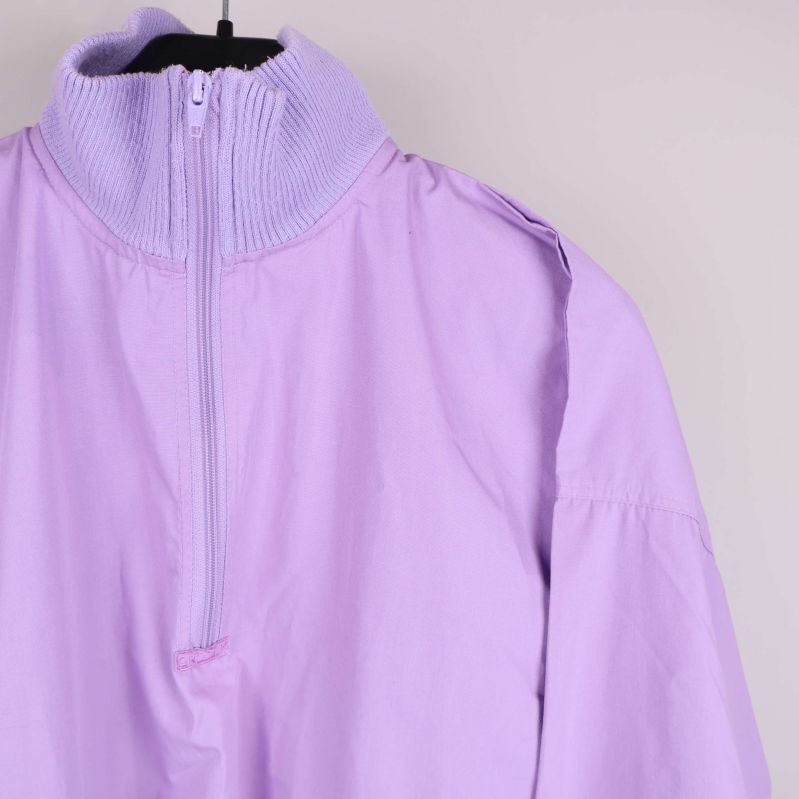 Närbild på ståkrage och dragkedja av ljuslila jacka