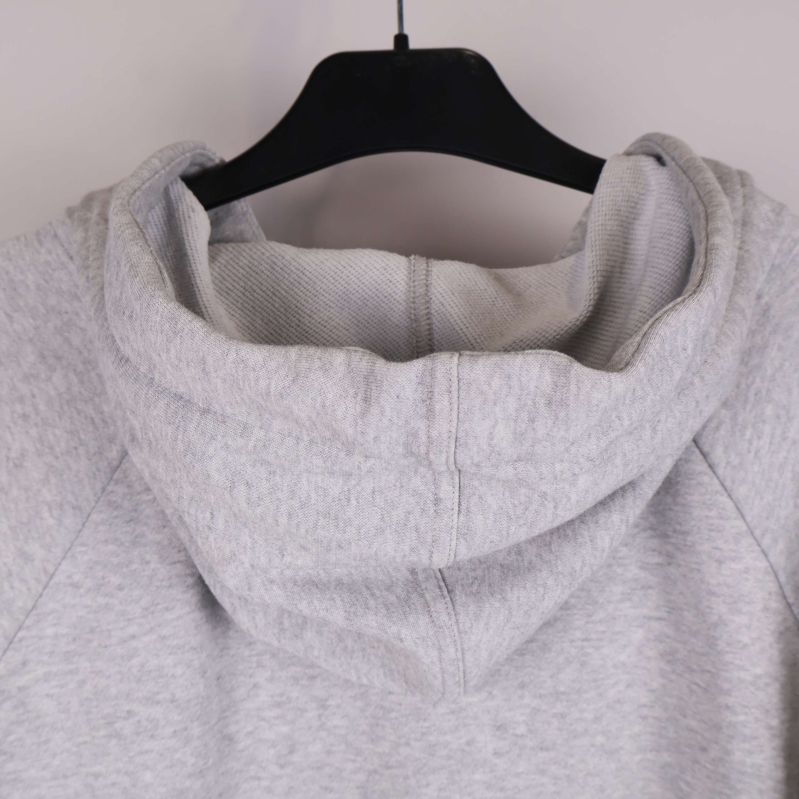 Närbild på hoodiehuva bakifrån i ljusgrått tyg