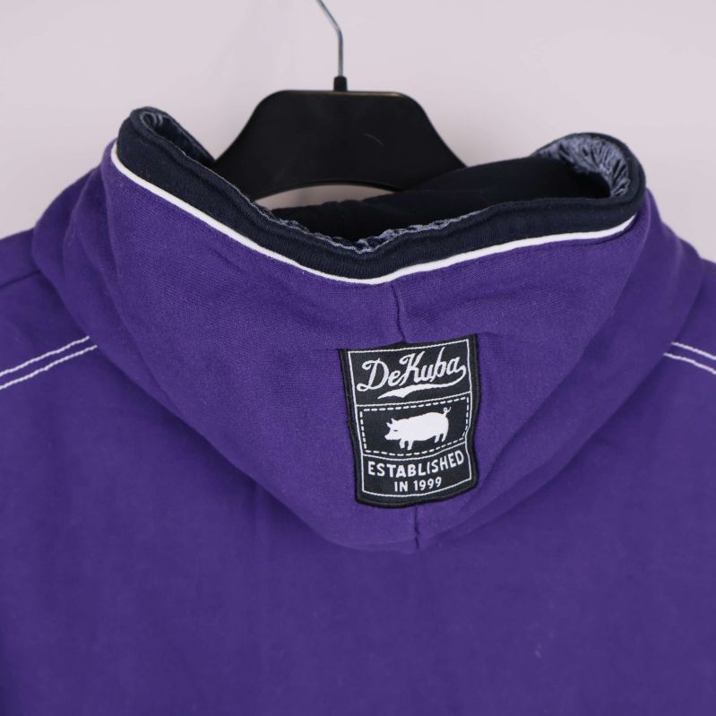 Etikett bak på huvan med DeKuba och griskmotiv