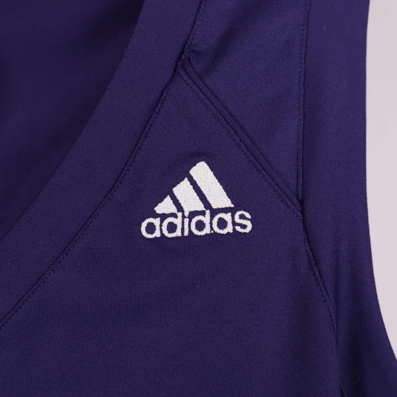 Närbild av vit broderad Adidas-logga framtill
