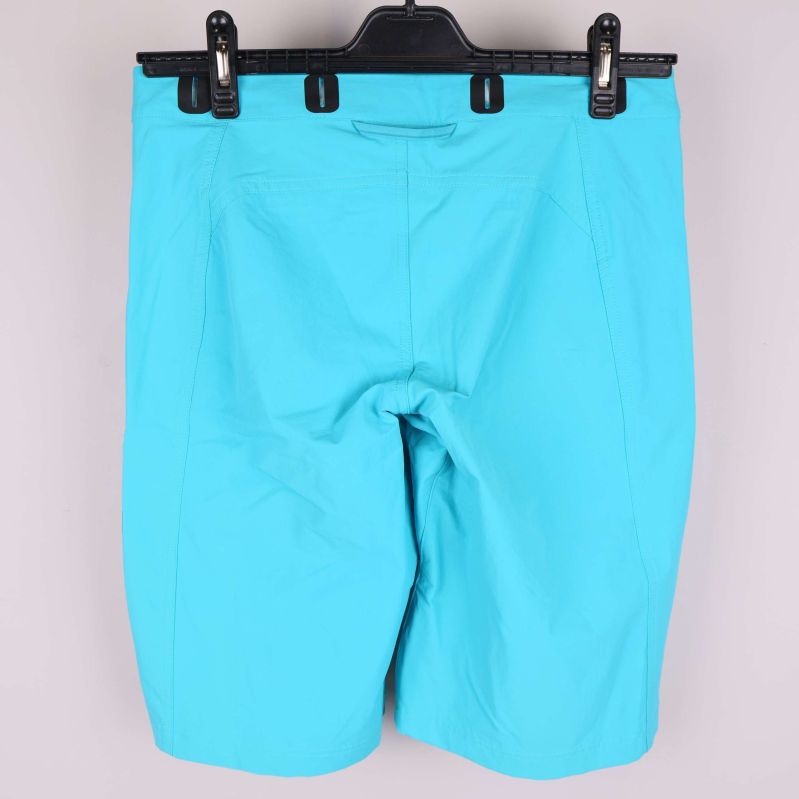 Baksidan av turkosa shorts utan synliga fickor