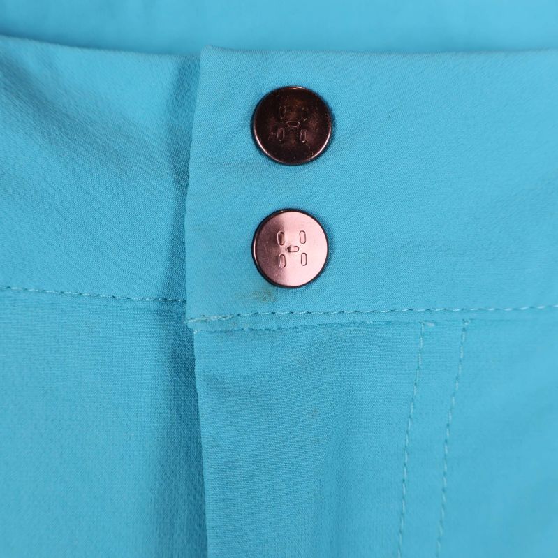 Två tryckknappar i midjan på turkosa shorts