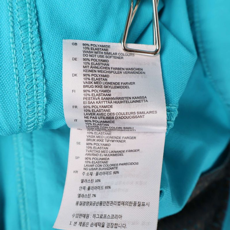 Materiallapp med information om tygblandning i shorts