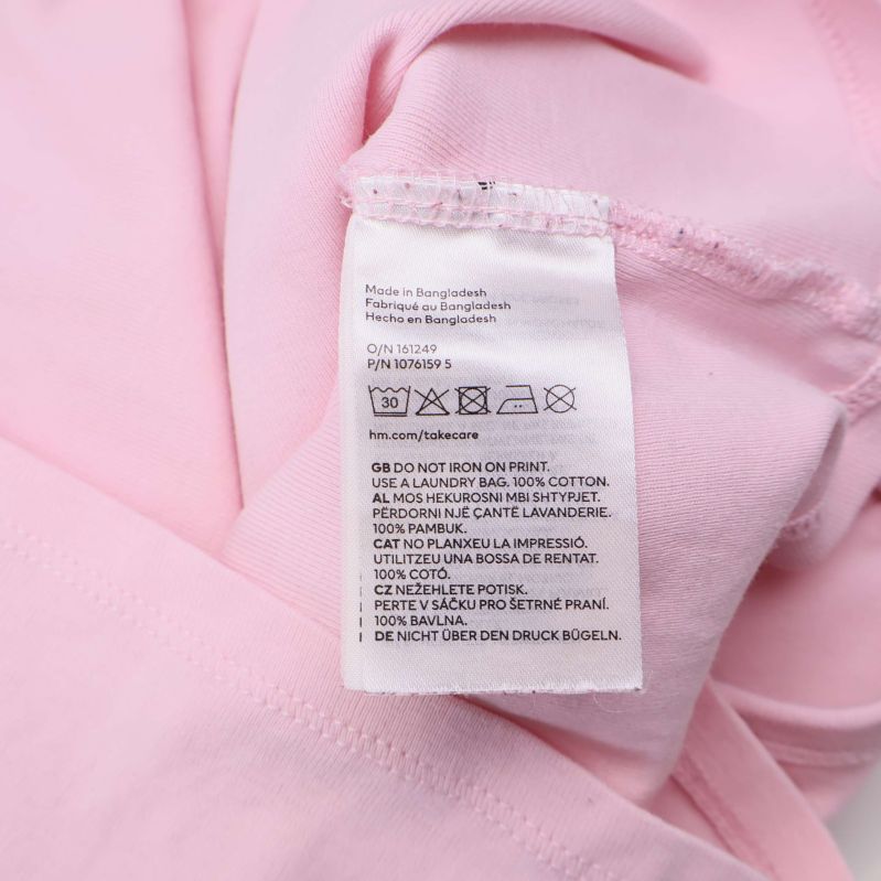 Material- och skötselråd närbild i vit text på etikett