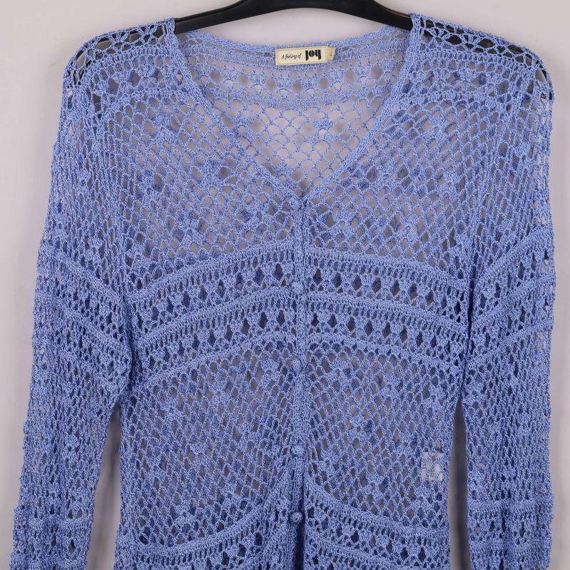 Närbild av cardiganens virkat mönster och V-ringning