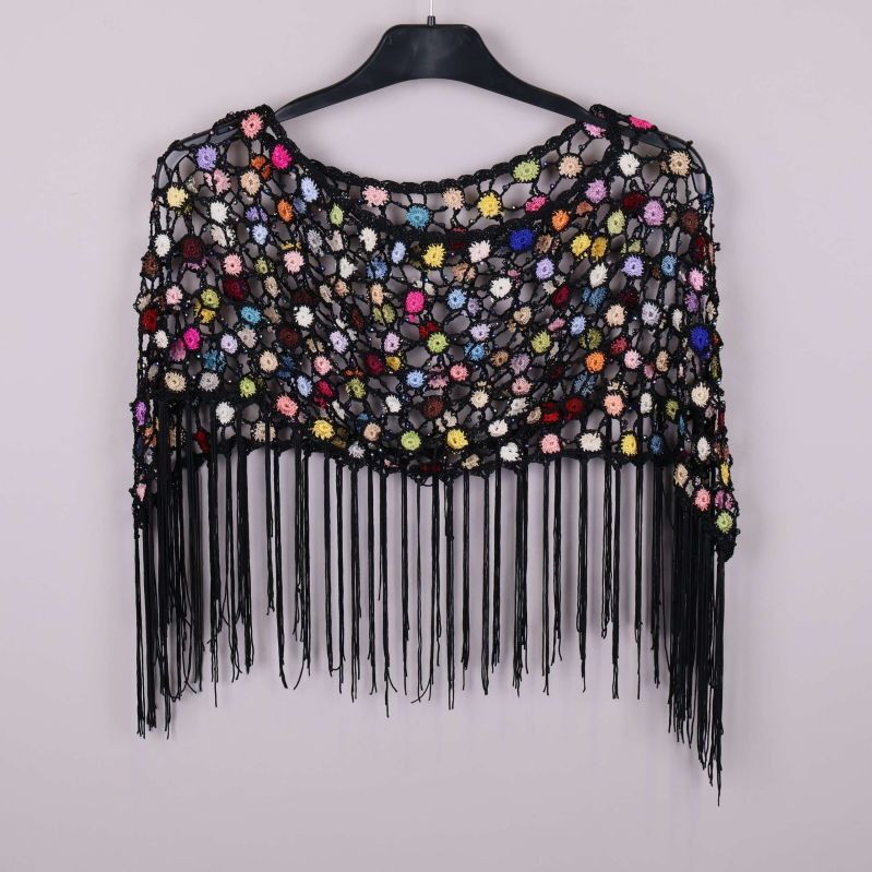 Bakre vy av virkad poncho med färgrika blommor och svarta fransar