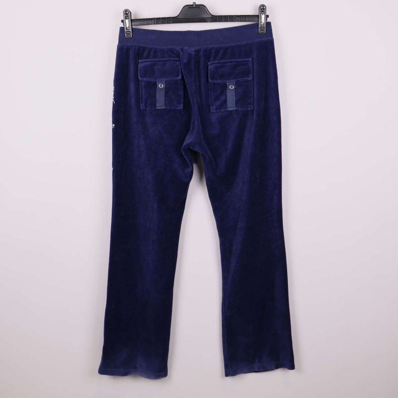 Baksidan av blå velourbyxor med bakfickor med lock