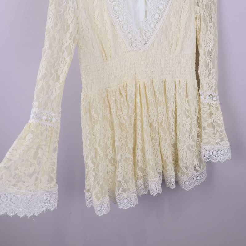 Klockärm och midjeparti på spetsblus syns från sidan