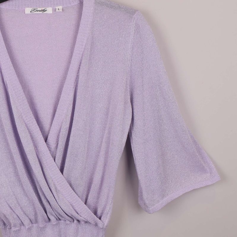 Närbild på glittrigt tyg och omlott-skärning vid ärmen