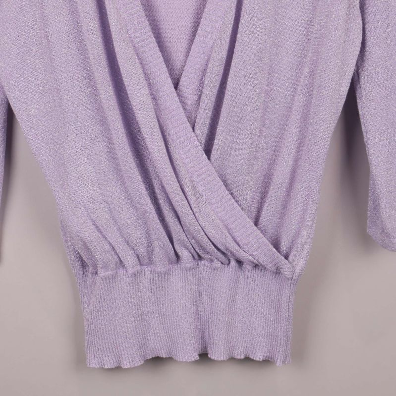 Resår i midjan och omlott-detalj i närbild på lila topp