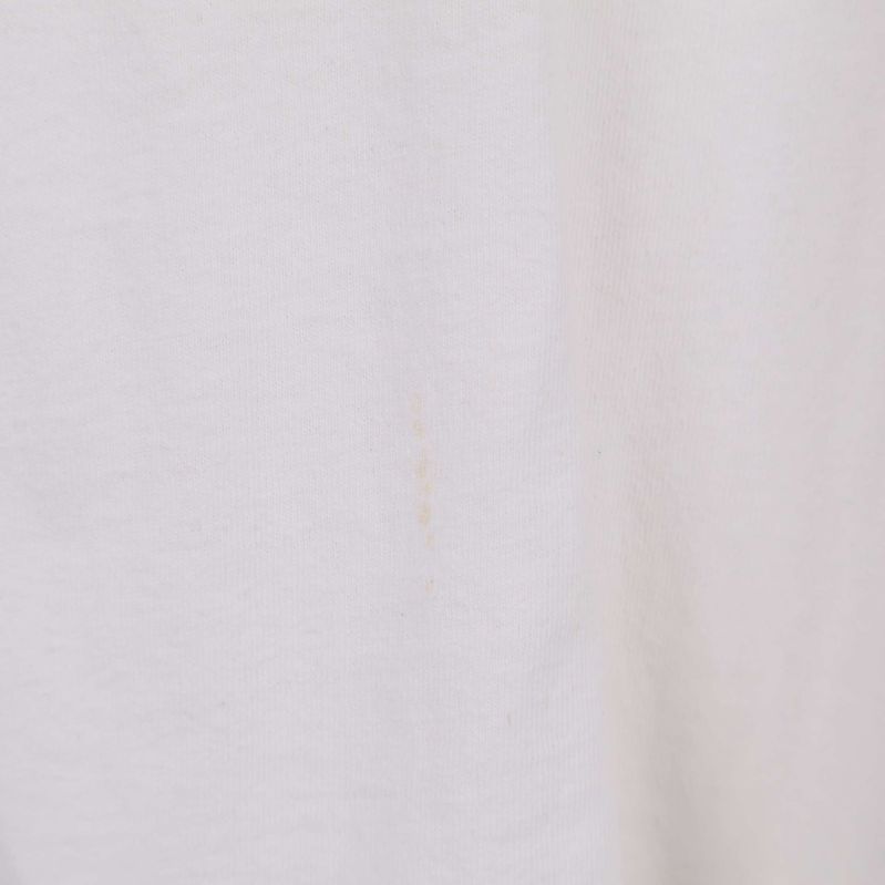 Närbild av litet fläck på vit t-shirt