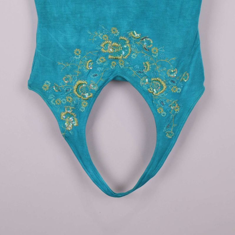 Närbild på broderi och paljetter på linnets framsida