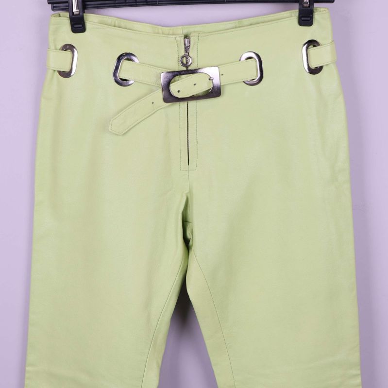 Närbild på midja och bälte på ljusgröna läderbyxor