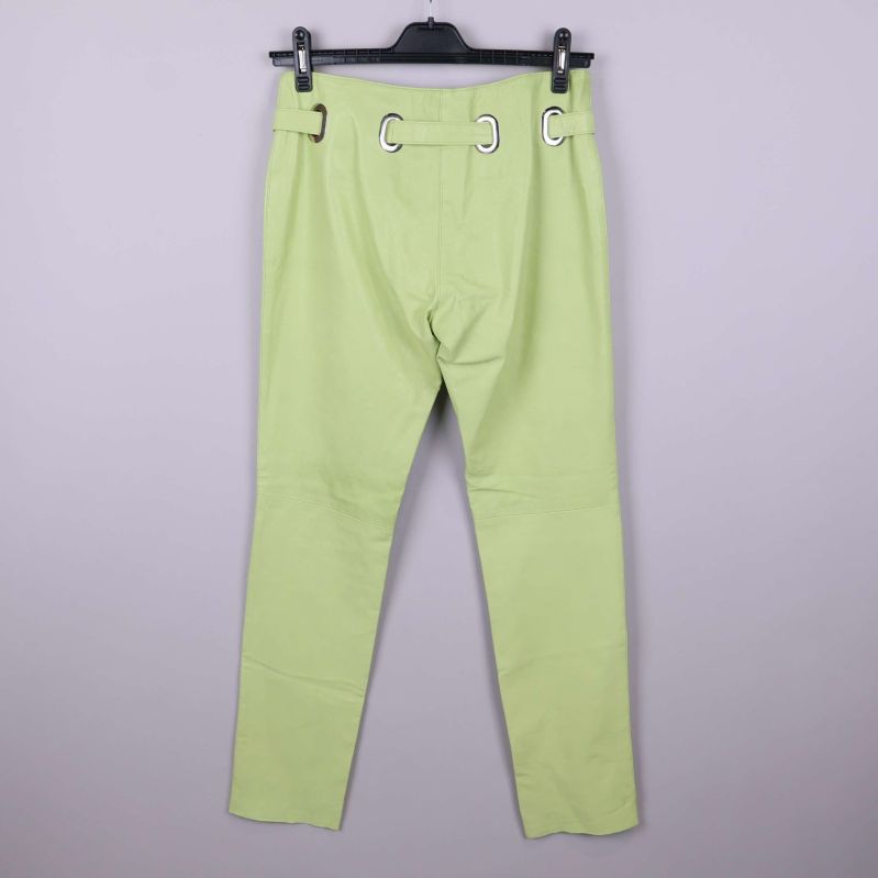 Baksida av ljusgröna läderbyxor med bältedetaljer