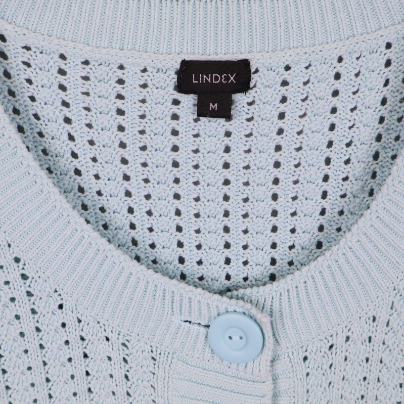 Närbild på Lindex-etikett och halsringning i ljusblå kofta