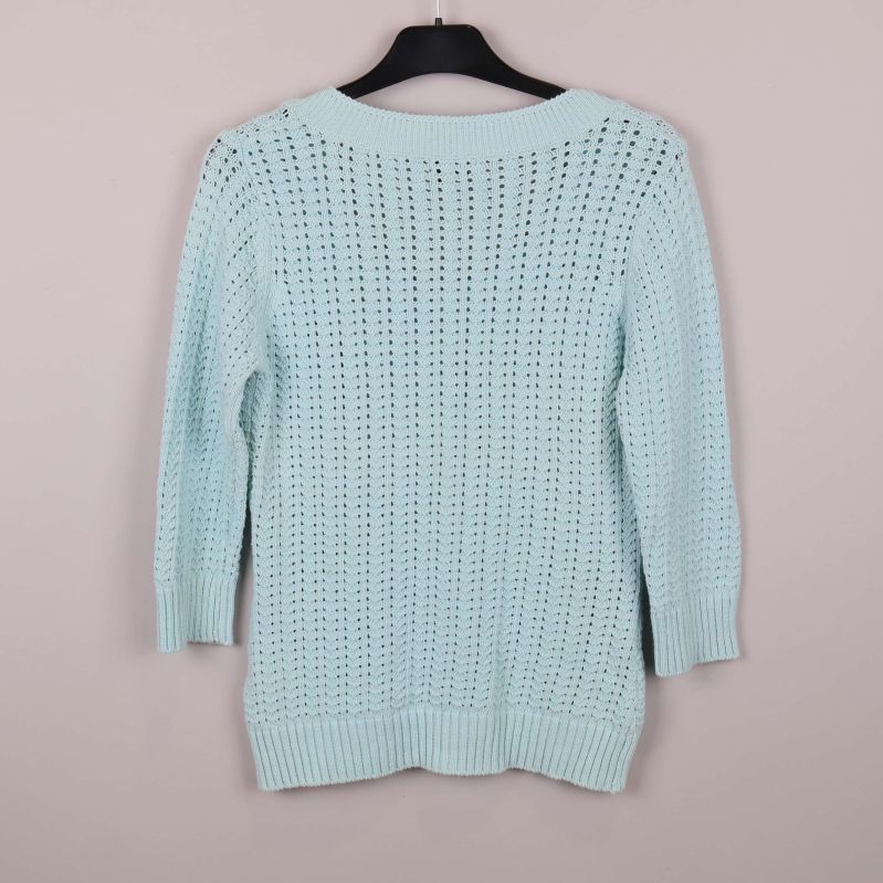 Baksida på ljusblå stickad kofta med hålmönster