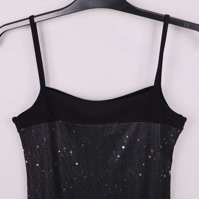 Närbild av klänningens svarta toppdel och axelband