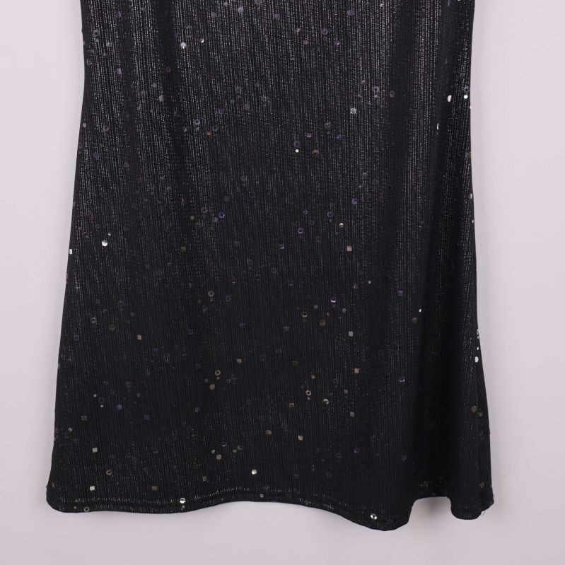 Nedre delen av svart klänning med glittriga paljetter