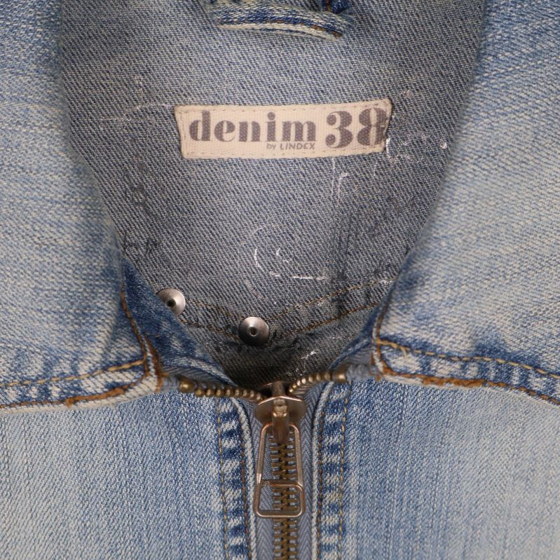 Närbild på etikett denim 38 från Lindex i jackans krage