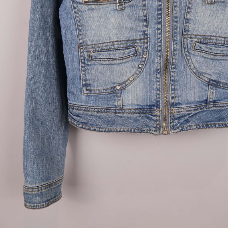 Ärm och nederkant av ljusblå jeansjacka med synliga sömmar