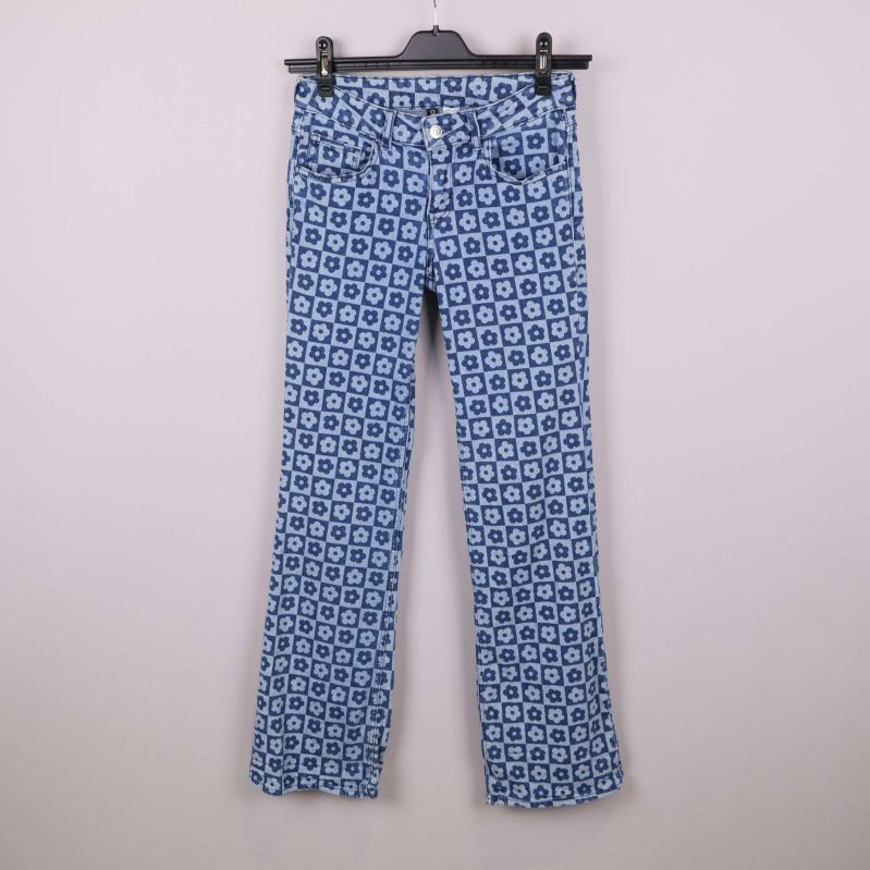 Jeans i helbild på galge med blåblommigt mönster