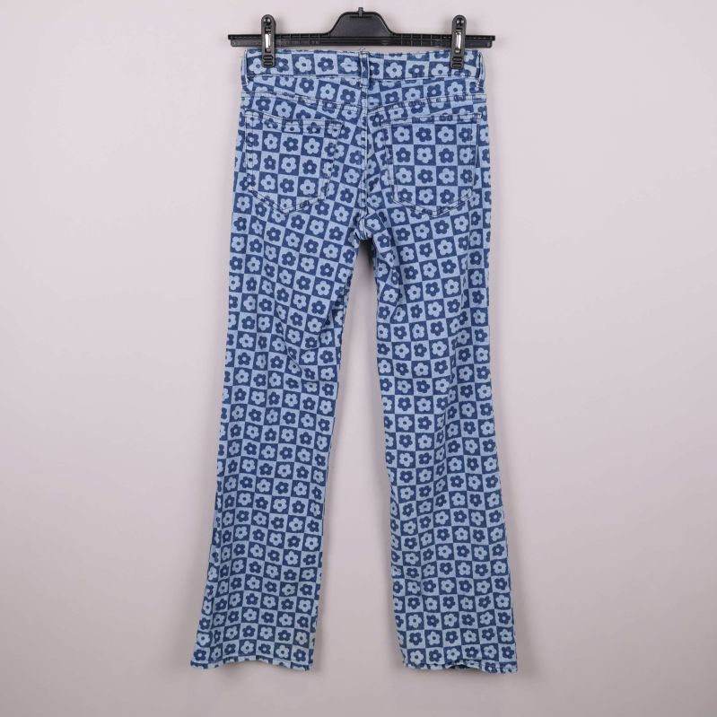 Baksidan av jeans med blommönster visas på galge