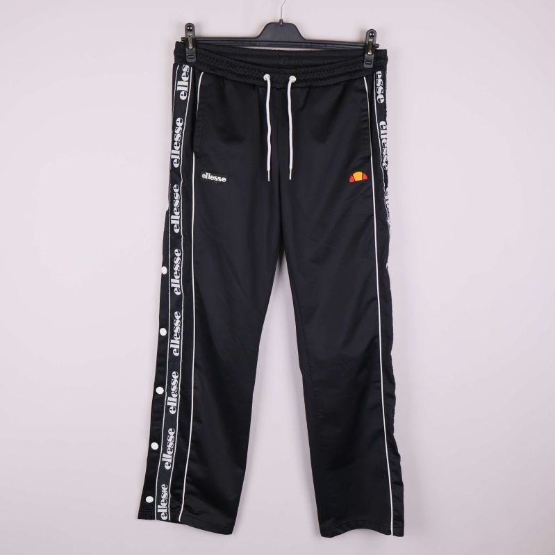 Svarta träningsbyxor med vita tryckknappar och logoband vid sidorna