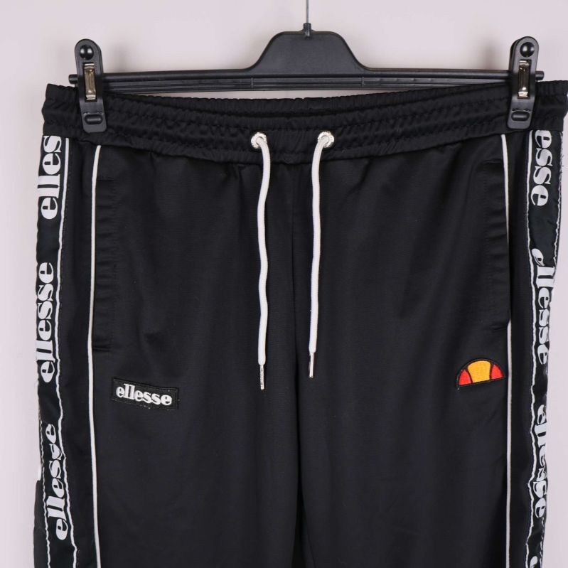 Framstycke med vita snören, broderade logos och logoband längs sidor