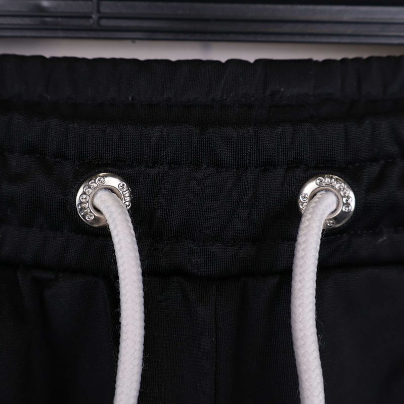 Närbild på de silverfärgade öljetterna och vita snörena vid midjan