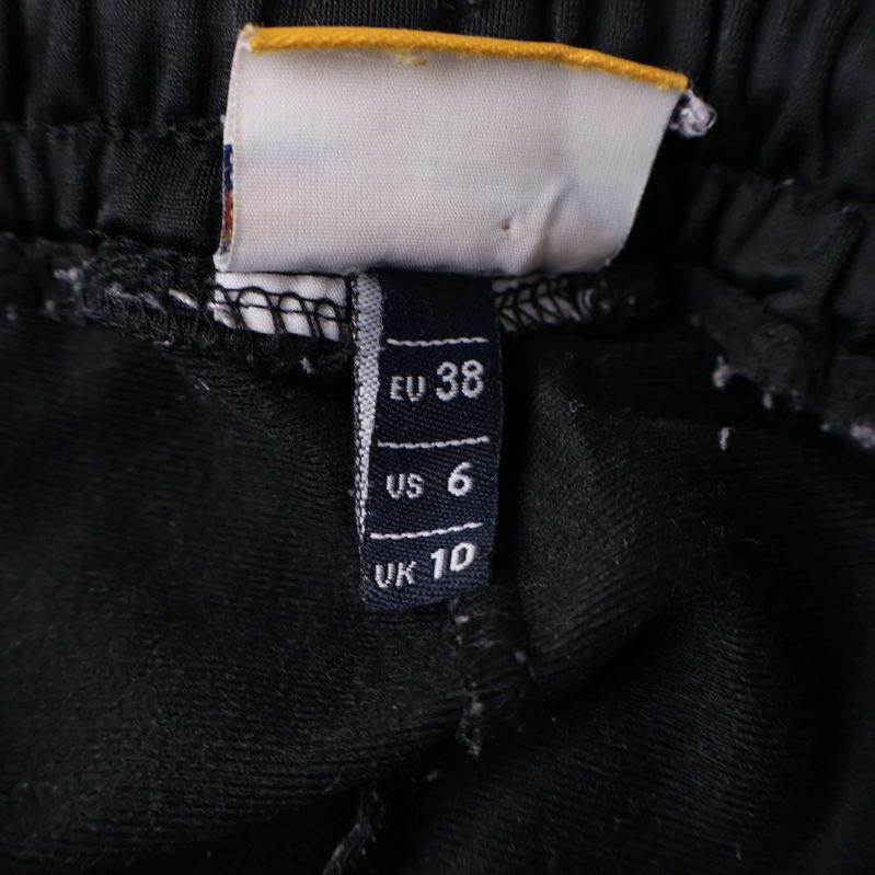 Storleksetikett visar EU 38, US 6, UK 10 i midjan