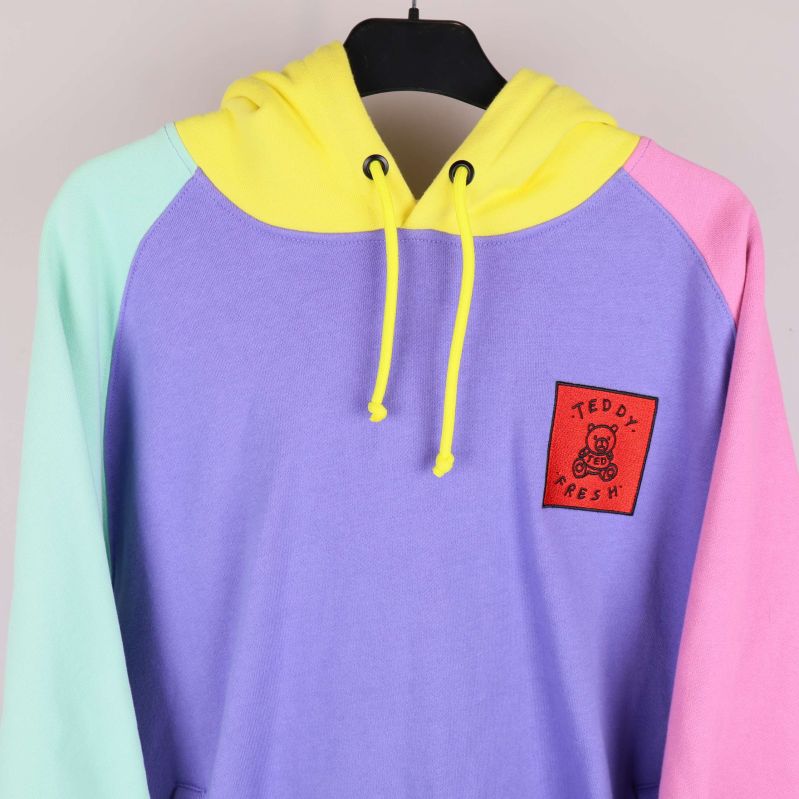 Detalj av lila bröstparti och röd Teddy Fresh-logga