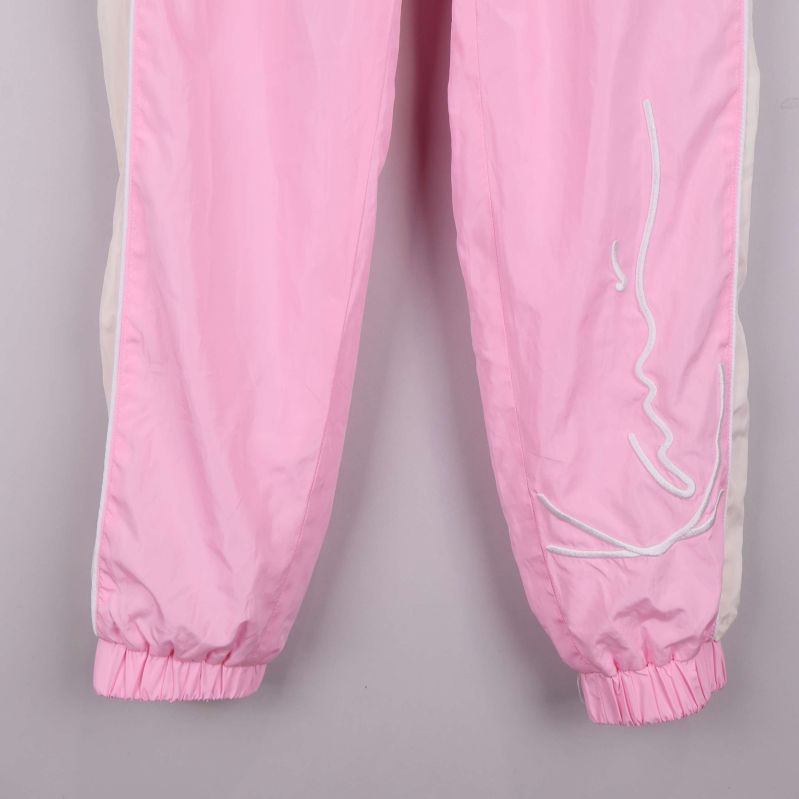 Detaljbild på nedre del med broderad logga vid benet