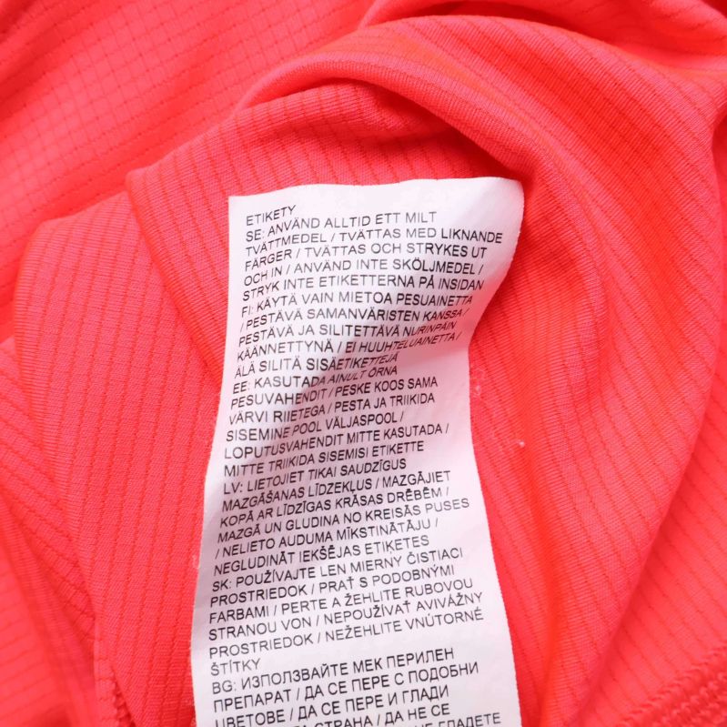 Tvättrådsetikett med materialinformation på flera språk