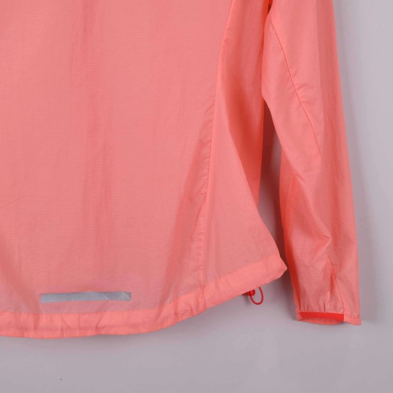 Närbild på nederkant och ärmslut av aprikos jacka