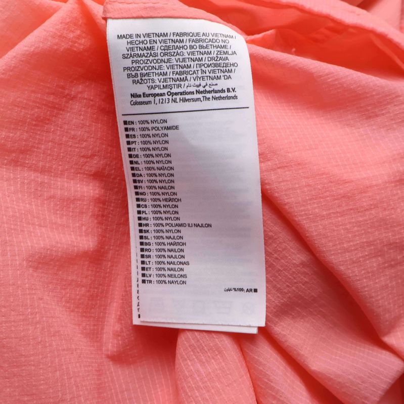 Materialetikett på insidan av aprikos jacka visas närbild