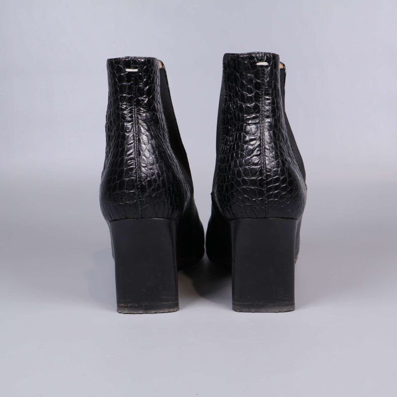 Bakifrån av boots med kraftig klack och krokoprägling