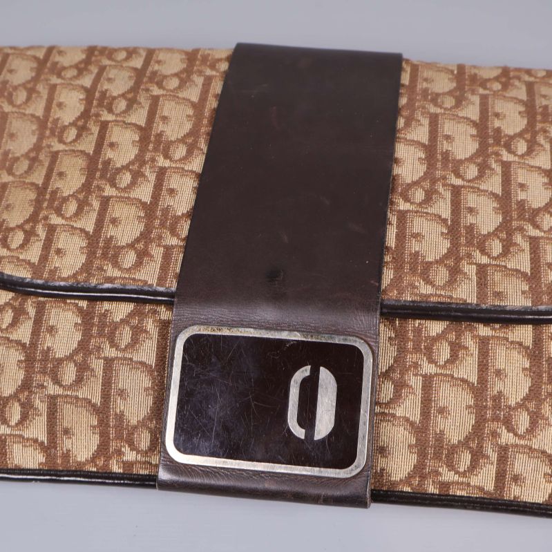 Närbild på väskans spänne och monogrammönster