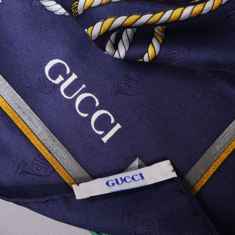 Närbild på tyg med tryckt och vävd Gucci-logotyp