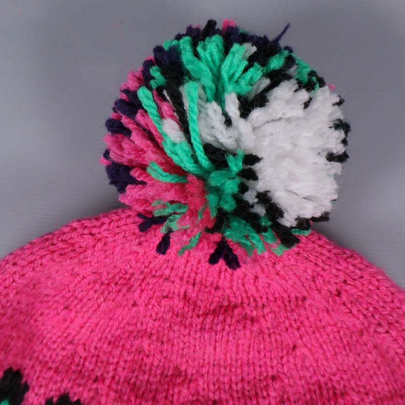 Närbild på tofs i grönt, vitt och svart