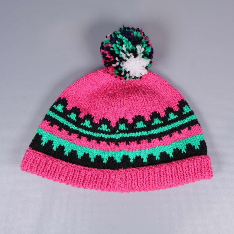 Stickad mössa med färgad tofs visad framifrån