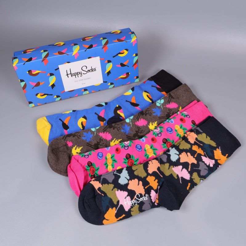 Fyra par färgglada strumpor bredvid en blå presentbox