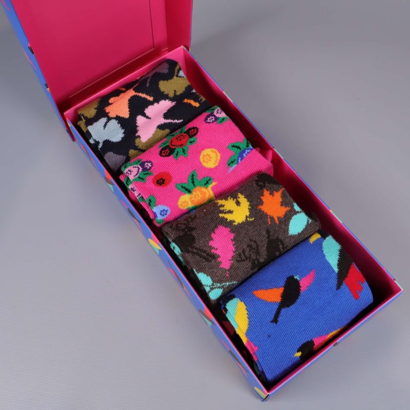 Öppen presentbox med fyra par färgglada strumpor